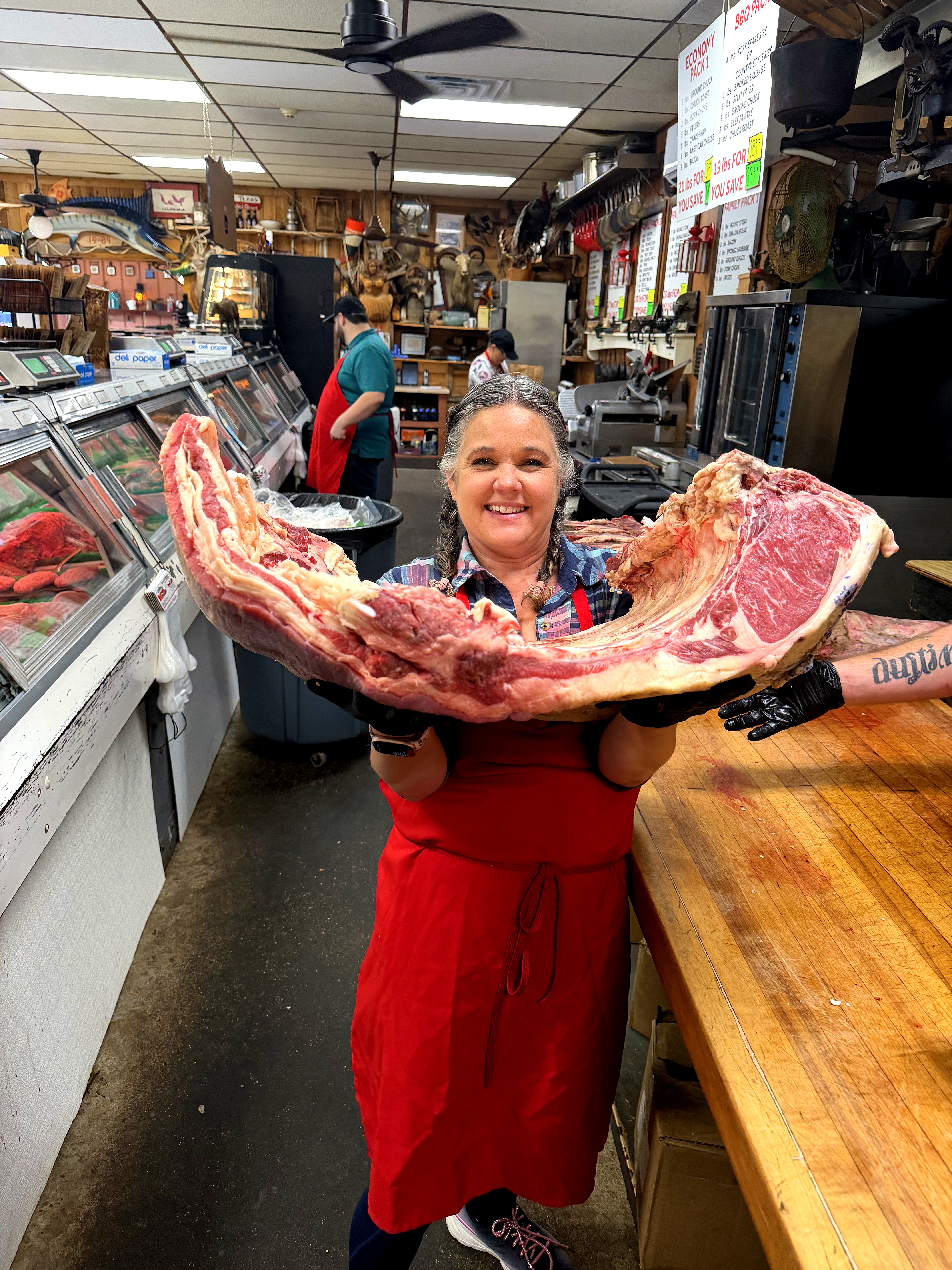 Co-owner presenting a fresh prime rib cut at Bay Area Meat Market